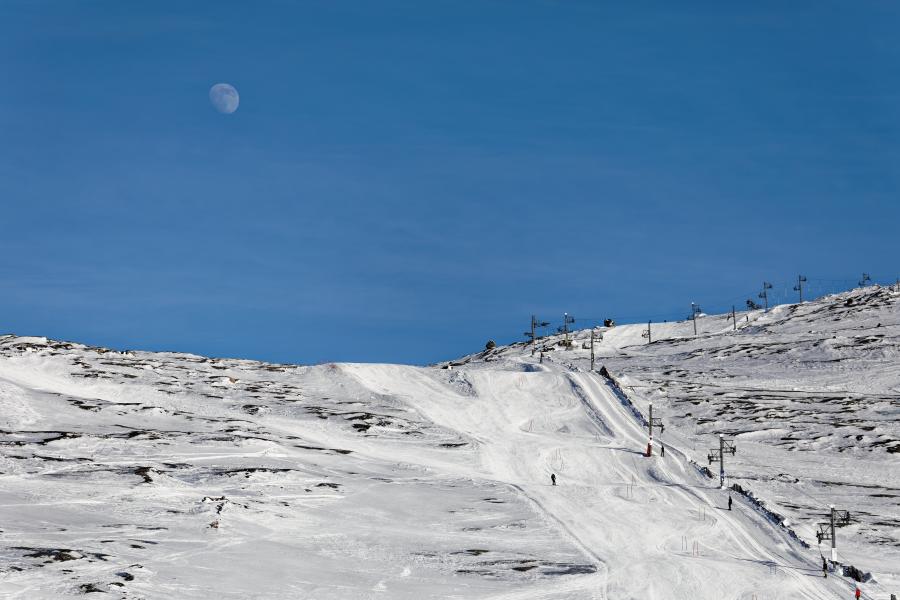 Skibakke i sol med måne